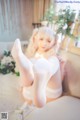 A woman in white stockings is sitting on a couch.