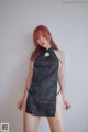 A woman in a black dress is posing for a picture.