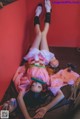 A woman in a pink kimono laying on the floor.