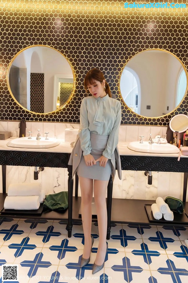 A woman standing in front of two sinks in a bathroom.