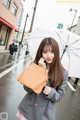 A woman holding an umbrella while standing in the rain.