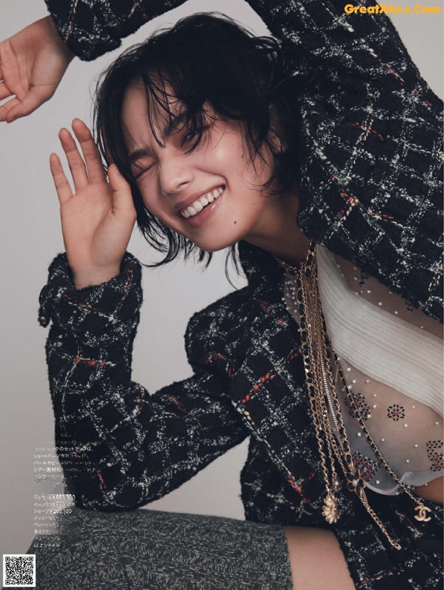 A woman in a black and white tweed jacket and skirt posing for a magazine.