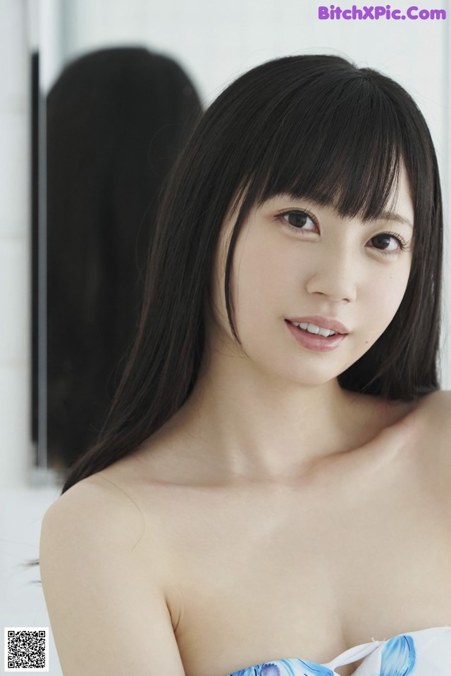 A woman in a blue and white dress posing for a picture.
