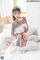 A woman with tattoos sitting on a bed.